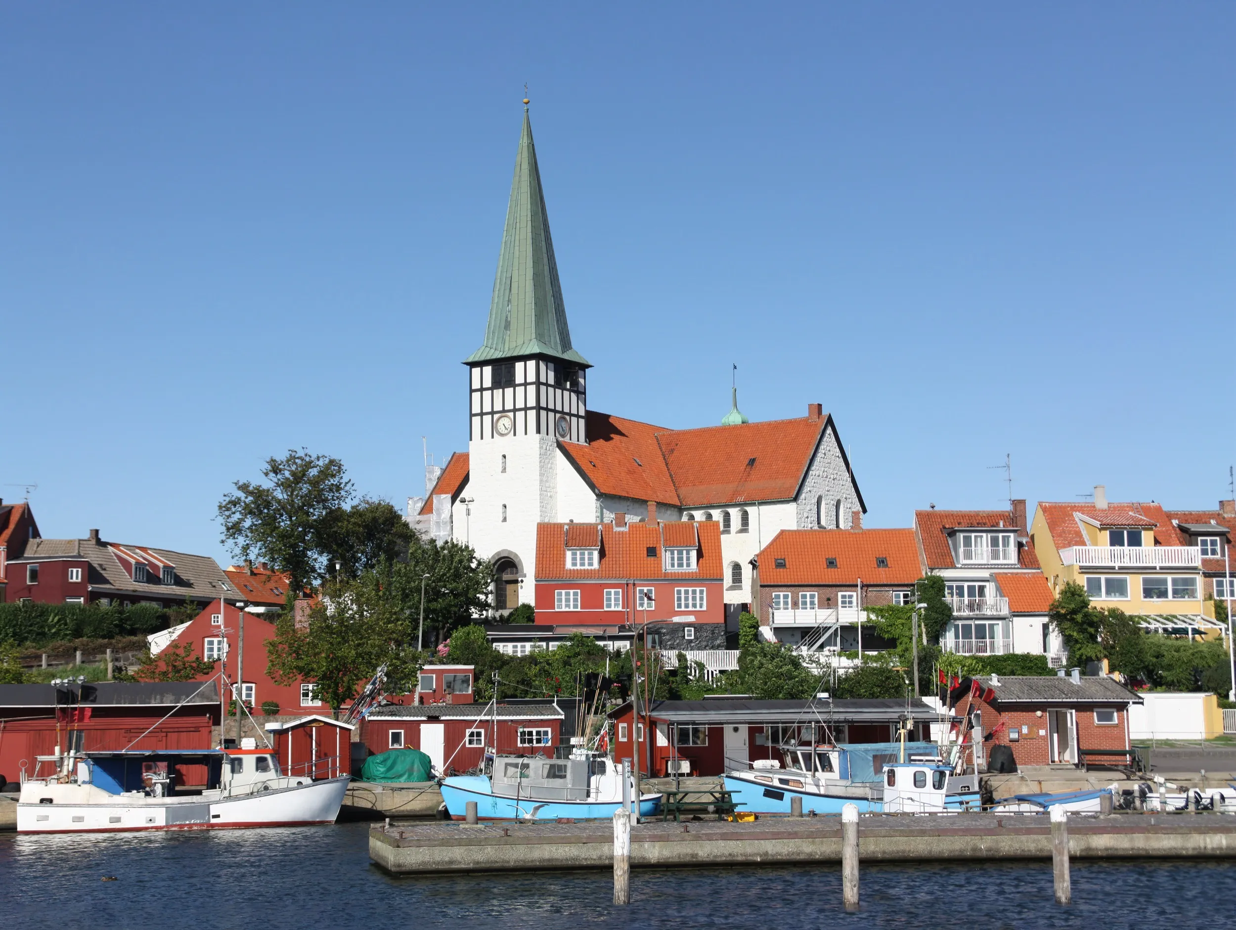 Blick vom Hafen auf die Sankt Nicolai Kirke und bunte Hafenhäuser von Rønne