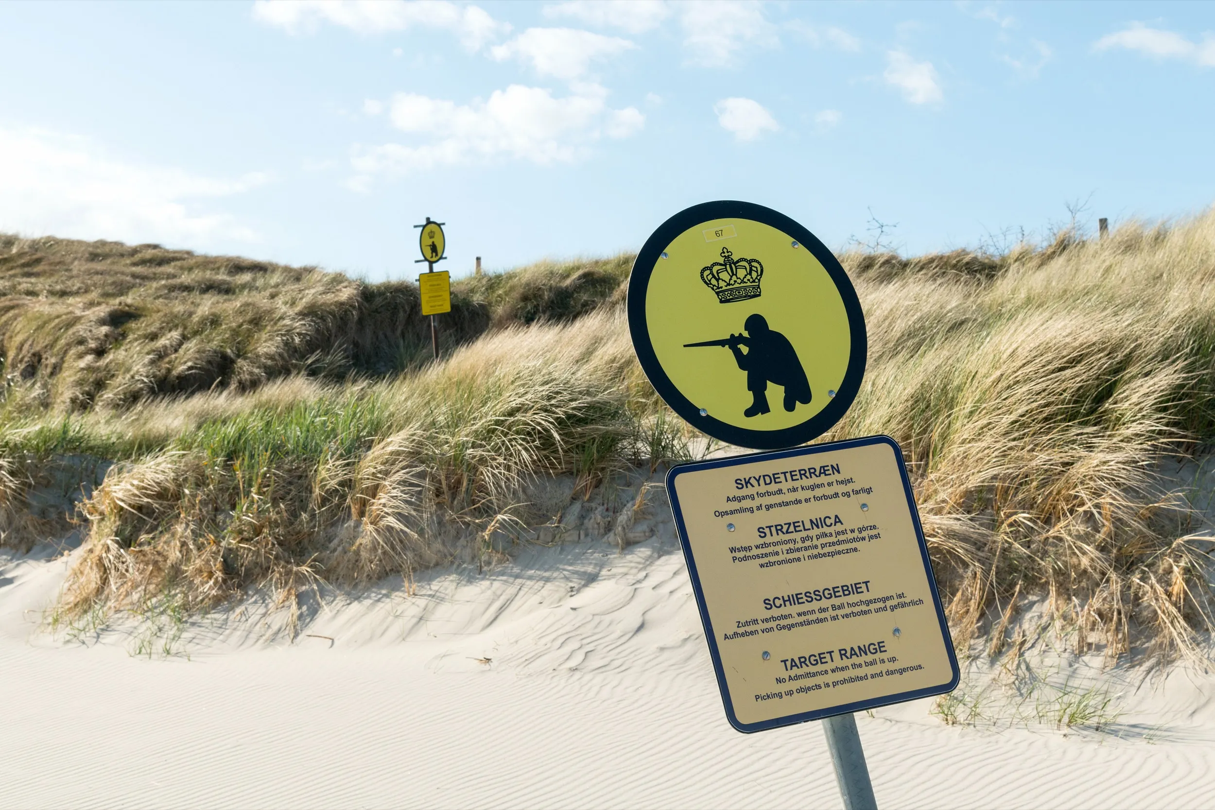 Mehrsprachige Warnschilder des Militärs in den Sanddünen