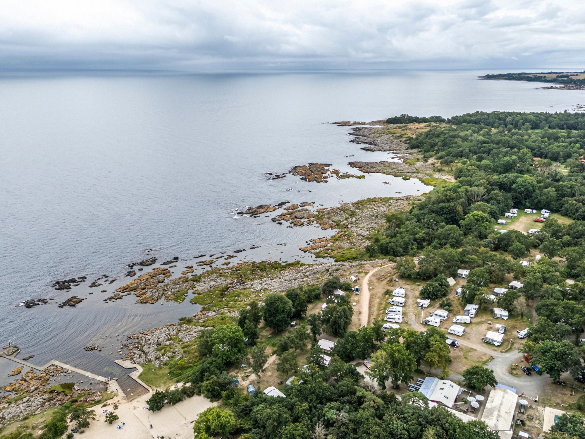 Luftaufnahme des Campingplatzes Hullehavn mit Küstenlinie und Waldgebiet auf Bornholm.