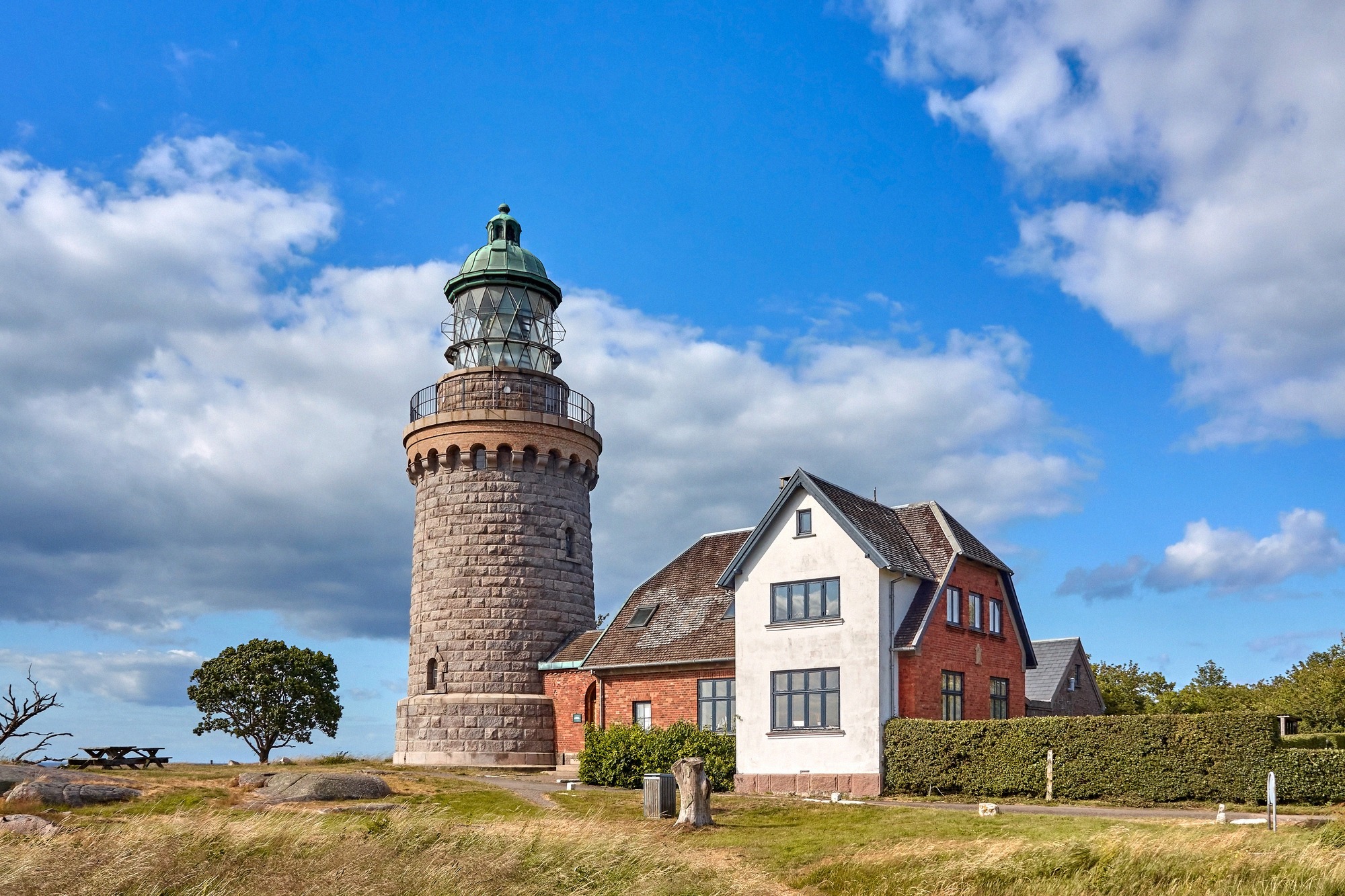 The decommissioned granite tower of Hammeren Fyr with its keeper's cottage amid open heathland