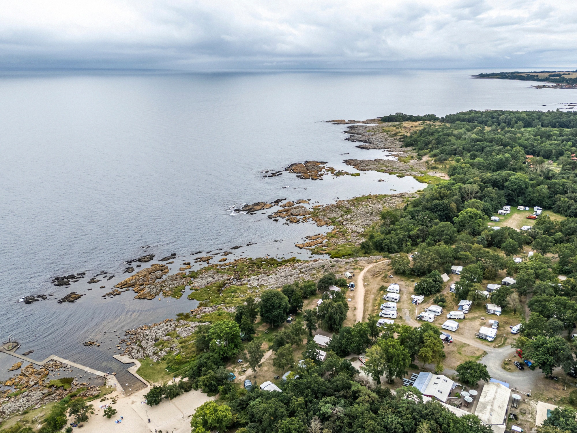 Hullehavn Camping bei Svaneke, direkt an der Felsküste. Drohnenaufnahme des Campingplatzes Hullehavn an der felsigen Ostseeküste bei Svaneke