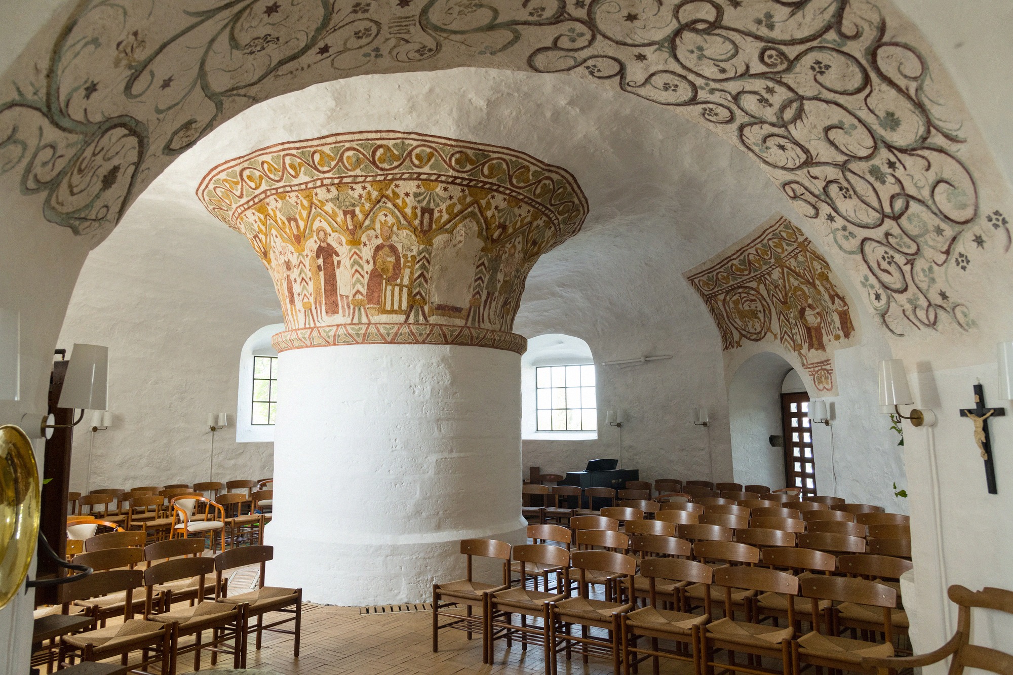 Interior of Ny Kirke with white central pillar and Romanesque frescoes